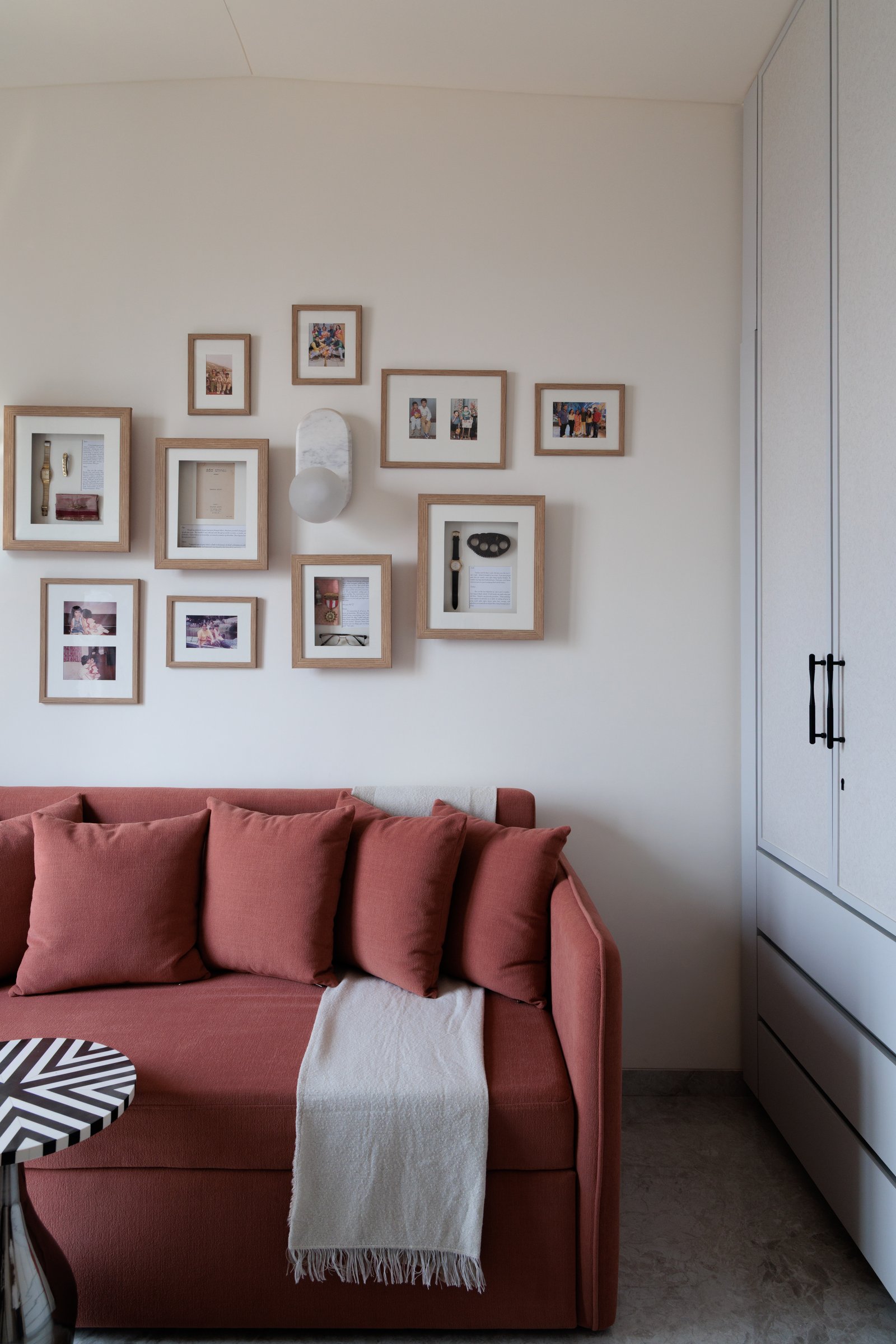 A gallery wall of framed family keepsakes, letters, and photographs, personal history mounted as art