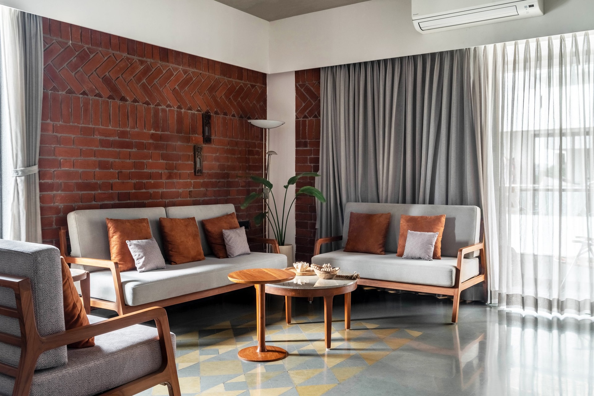 The living room's brick feature wall, its herringbone banding a quiet record of the mason's craft